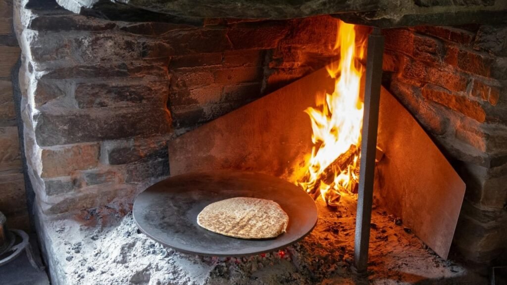 Lavash bread on Iron plate and fire in stove