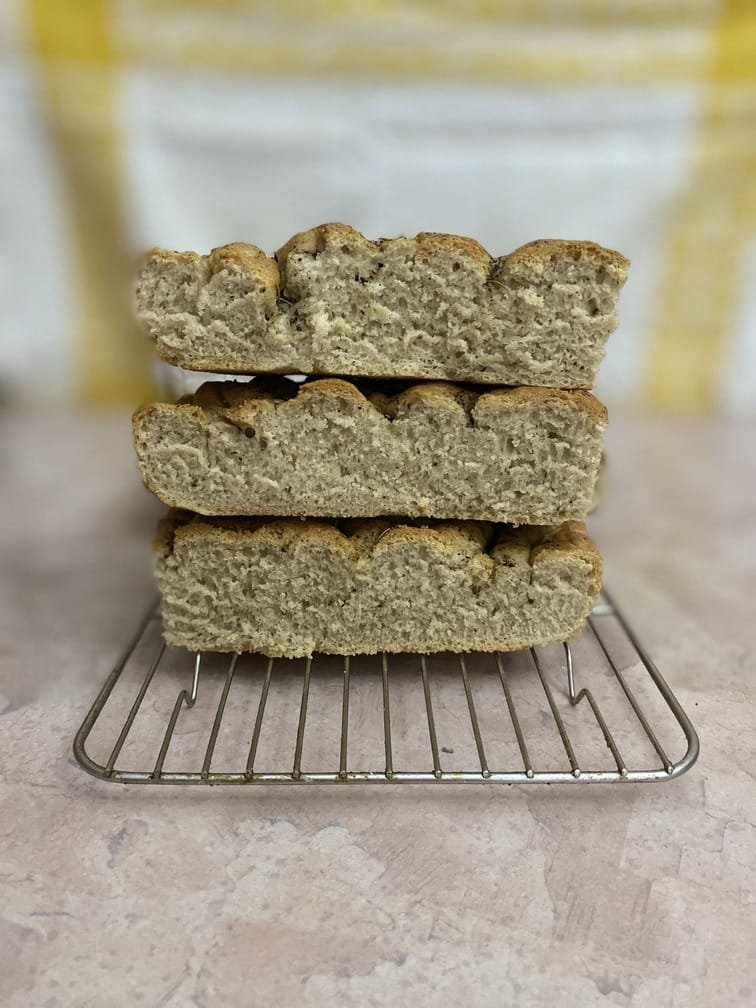 a slices of black pepper focaccia on a cooling rack