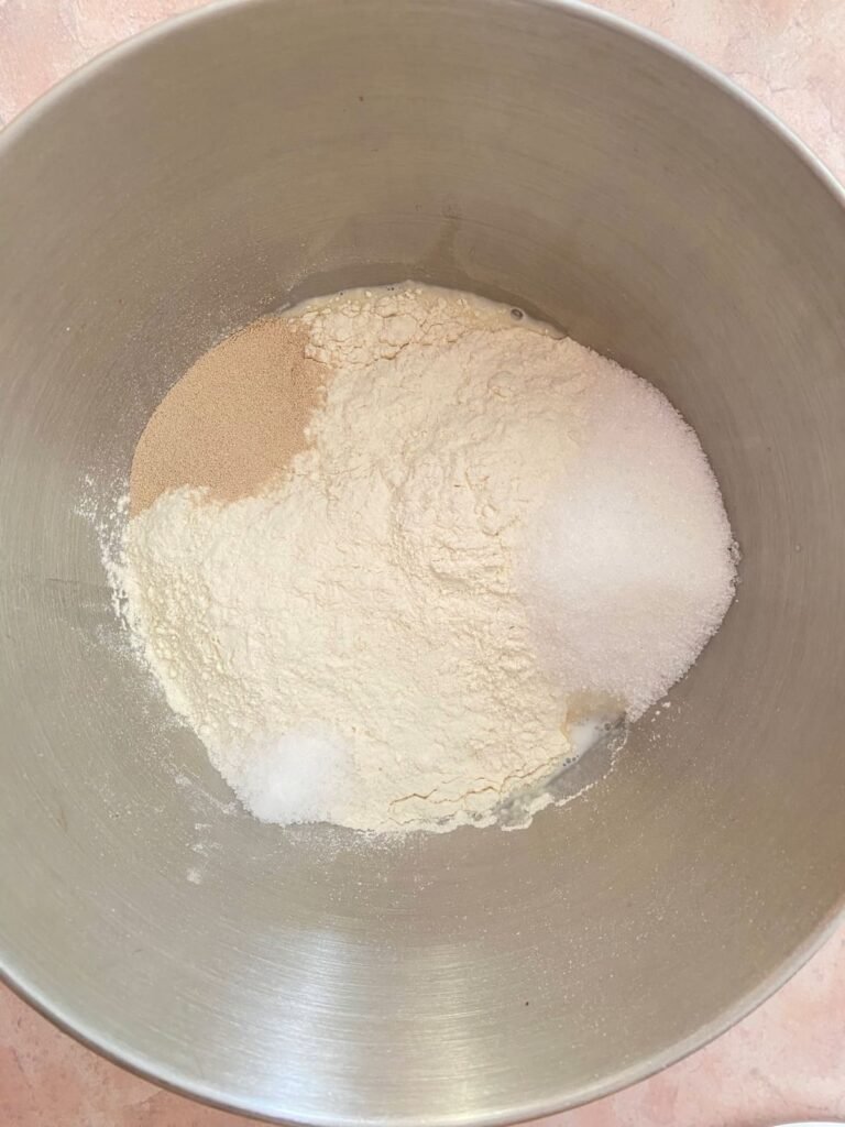 Milk, eggs in a bowl followed by flour, sugar, salt and yeast