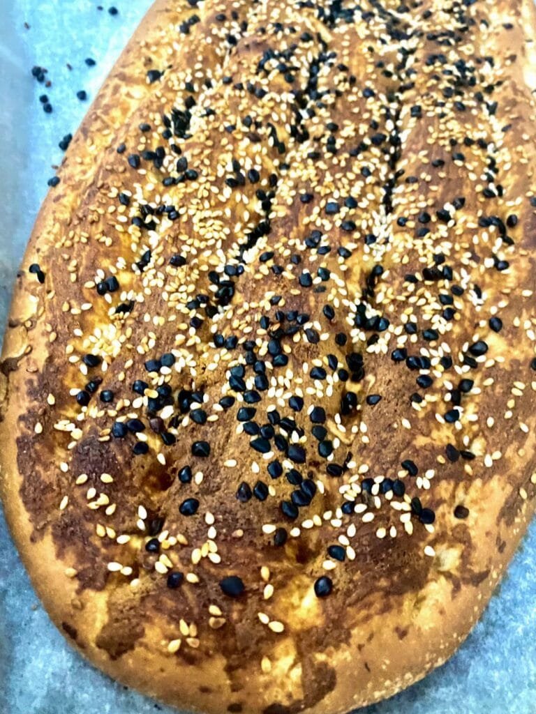 Close-up photo of fresh barbari bread on parchment paper.