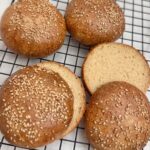 sliced gluten free hamburger buns on wire rack.