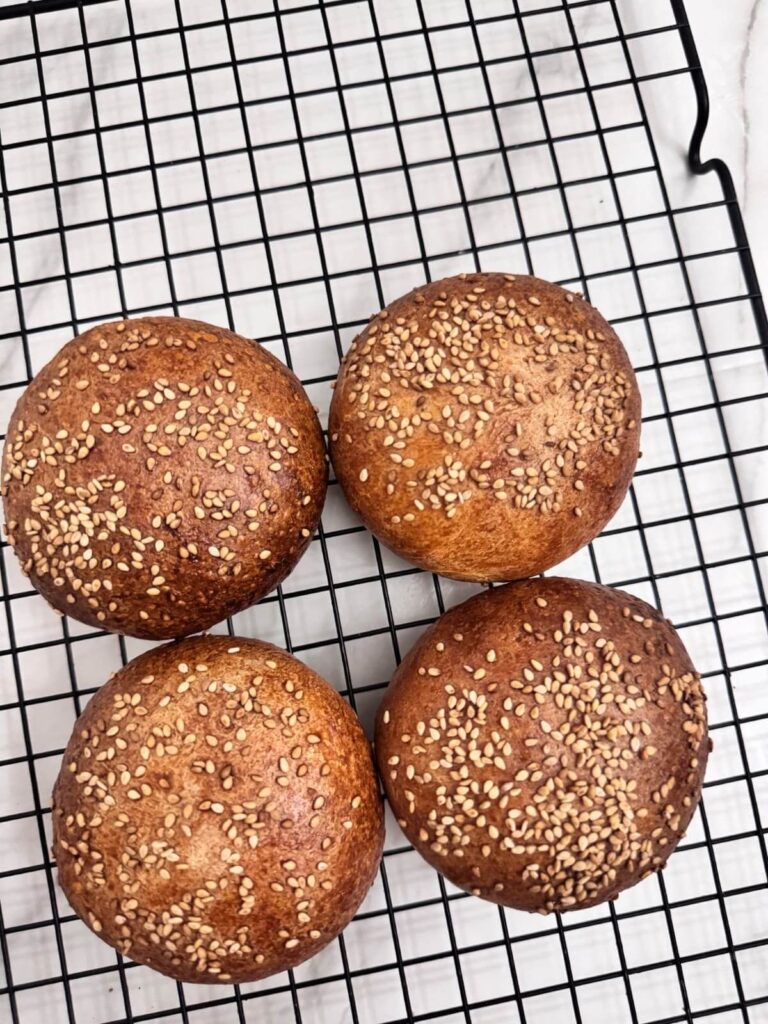 Close up of 4 gluten-free hamburger buns on wire rack.