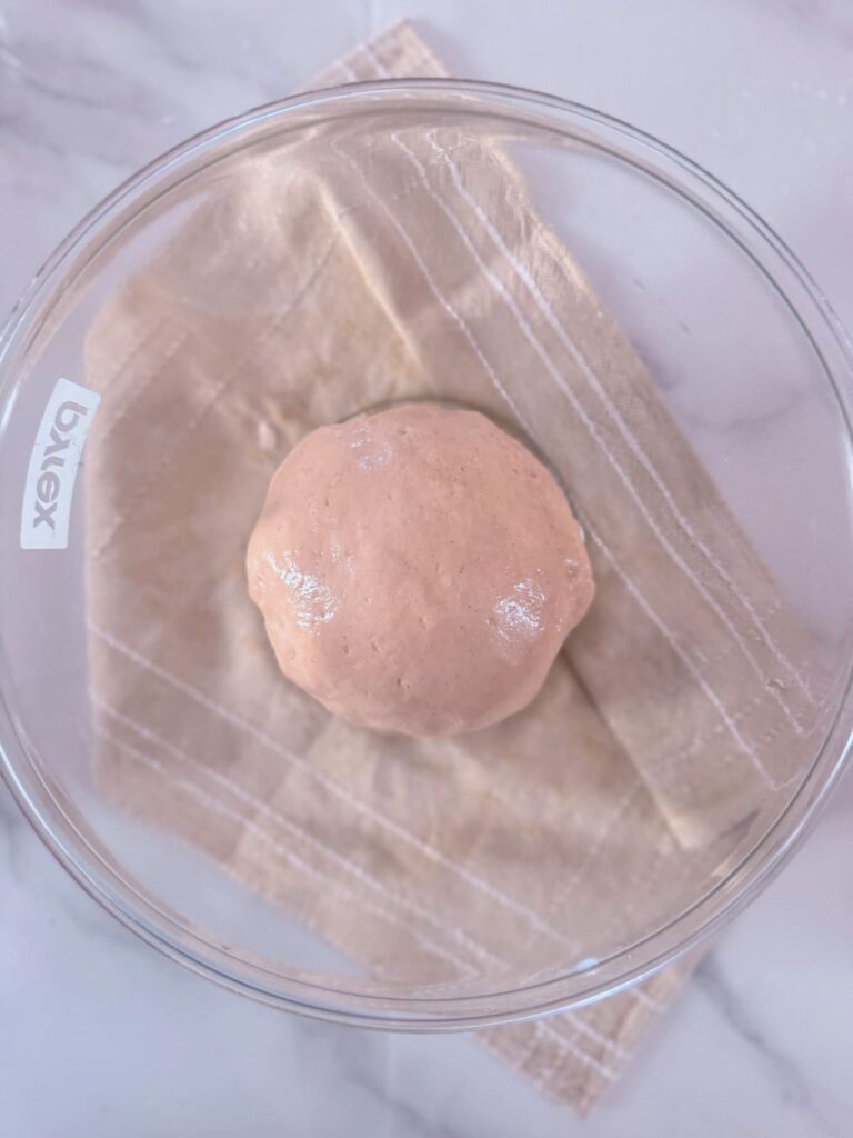 gluten-free dough ball  in an oiled bowl.