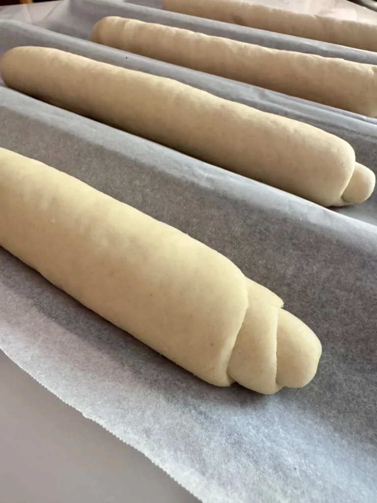 placing the shaped hoagie rolls on baguette pan