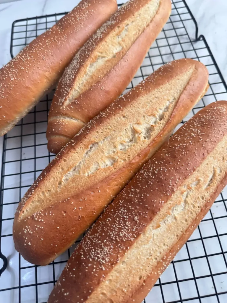 A close-up photo of hoagie rolls in a cooling rack.