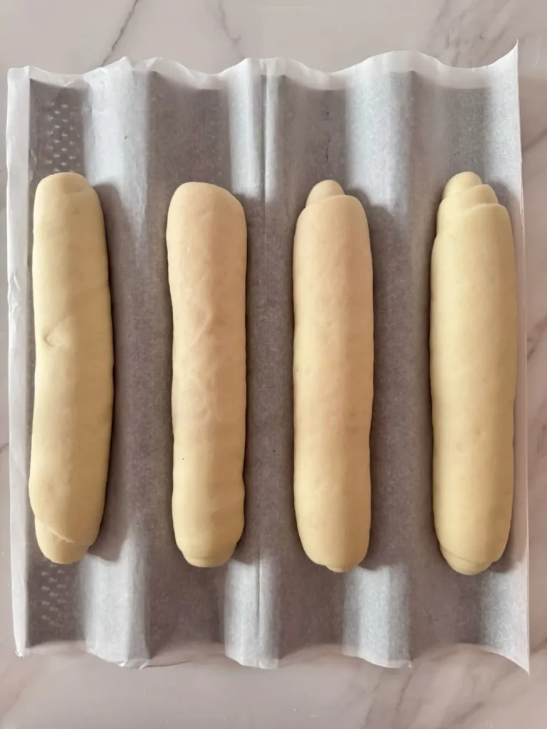 Proofed hoagie rolls before milk wash