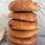 A stack of five golden brown Lepinja breads piled vertically