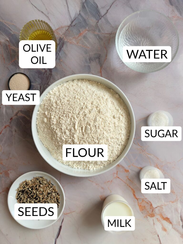 close-up, overhead shot shows the ingredients for Lepinja flatbread: flour, yeast, salt, water, milk, and other ingredients in small plates and bowls.