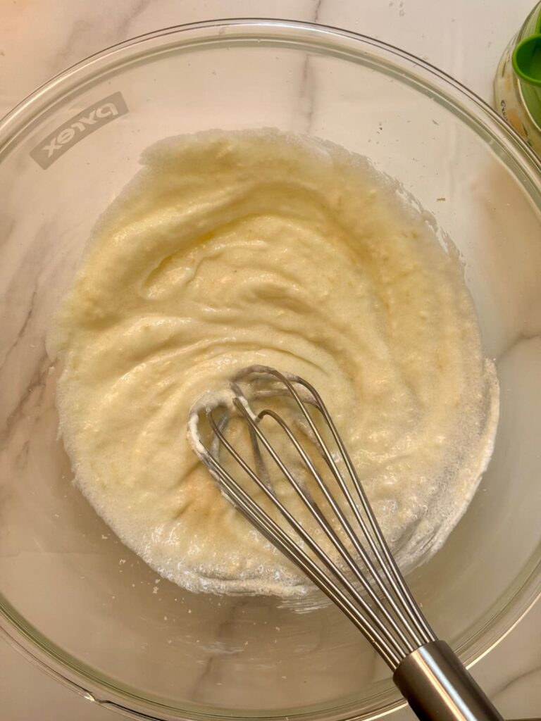 A close-up view of lemon poppy seed batter after whisking the wet ingredients.