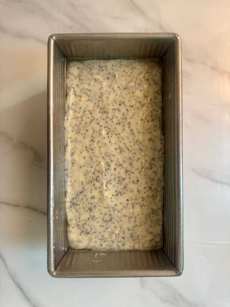 A close-up, top view of lemon poopy seed butter on loaf pan.