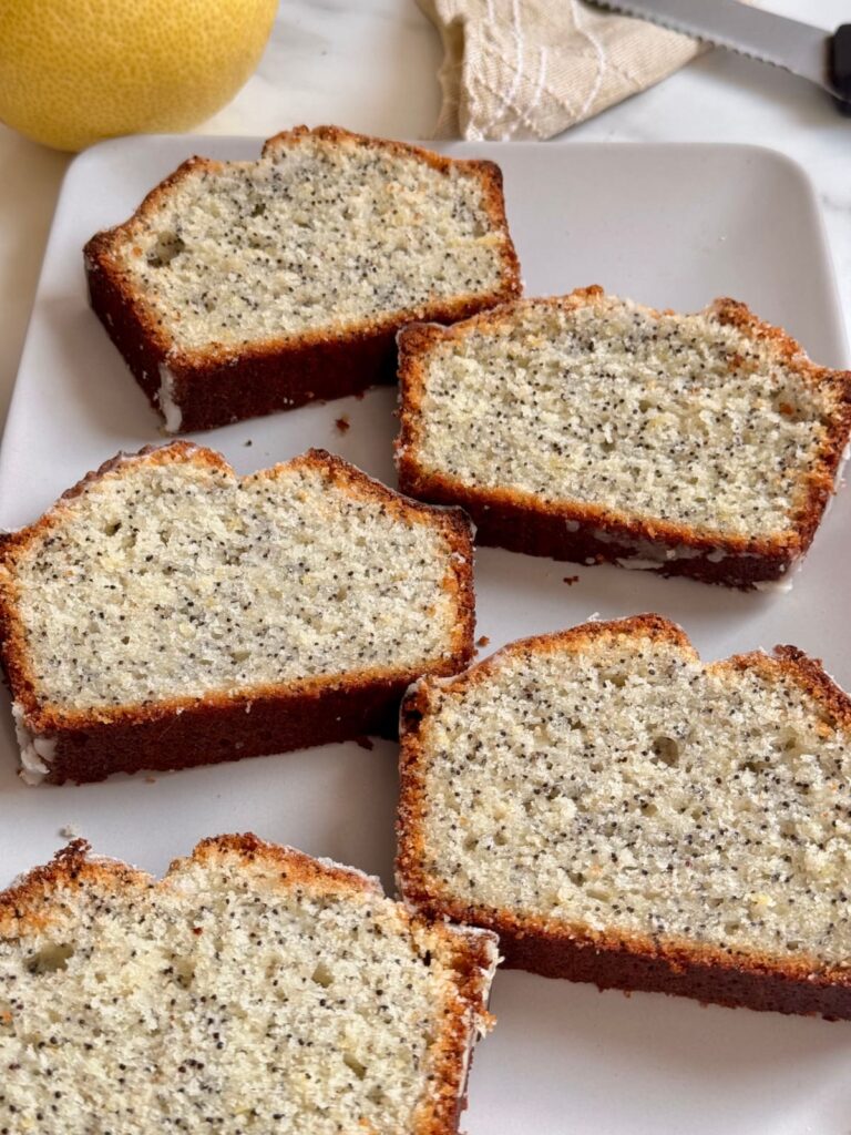 five slices of fresh lemon poppy seed bread on white plate.